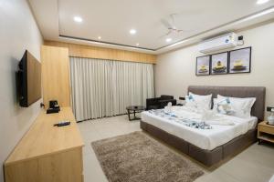 une chambre d'hôtel avec un lit et une télévision dans l'établissement Vindhyachal Resort, à Kevadia
