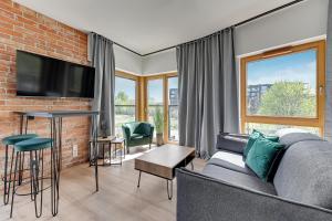 een woonkamer met een bank en een bakstenen muur bij Downtown Apartments Nadmotławie Estate Gym, Sauna & Parking in Gdańsk