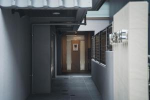 Hotel Star Residence - 無人ホテル في فوكوكا: ممر في مبنى مع ممر يؤدي إلى باب
