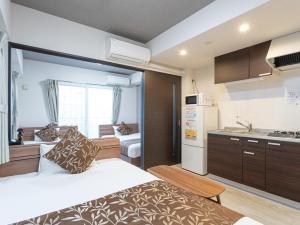 Habitación pequeña con cama y cocina en Dream Inn Hakata en Fukuoka