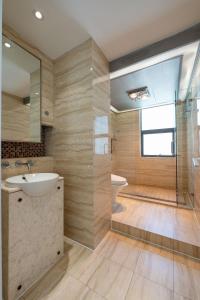 La salle de bains est pourvue d'un lavabo, d'une baignoire et d'une douche. dans l'établissement Shanghai Xintiandi Taipuqiao Tianzifang near the Bund Sunny Cozy Deluxe Room, à Shanghai