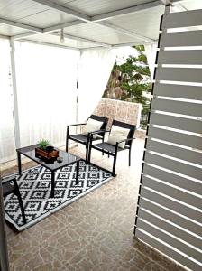 - une terrasse couverte avec 2 chaises et une table dans l'établissement Renovated Loft near the Center, à Héraklion