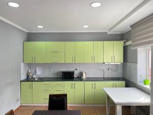 a kitchen with lime green cabinets and a table at Sultan in Bishkek