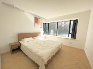 Un dormitorio con una cama grande y una ventana en Shanghai Jing'an Temple, Sunny Capital, Deluxe Three-Bedroom Apartment B&B, Extra Large Space en Shanghái