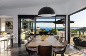 uma sala de jantar com uma mesa e algumas cadeiras em Cable Bay Views em Oneroa