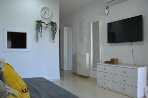 Gemelos IV 5B Holiday Apt في بنيدورم: غرفة معيشة مع تلفزيون وخزانة بيضاء