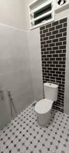 een badkamer met een toilet en een zwart-witte tegelvloer bij ISTANA VIEW HOMESTAY (Home C) in Kota Bharu