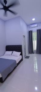 een slaapkamer met een bed en een plafondventilator bij ISTANA VIEW HOMESTAY (Home C) in Kota Bharu