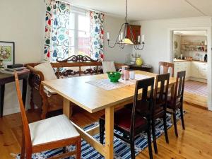 a kitchen and dining room with a wooden table and chairs at 8 person holiday home in HÖGSBY in Högsby +19 photos