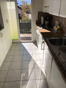 a kitchen with white cabinets and a sink and a window at Sunny and cozy flat with breathtaking views in Brissago +12 photos
