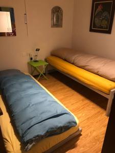 a room with two beds and a table with a lamp at Sunny and cozy flat with breathtaking views in Brissago