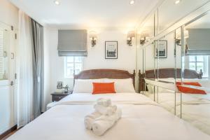 Un dormitorio con una cama blanca con toallas. en Cherie Bangkok Boutique Hotel en Bangkok