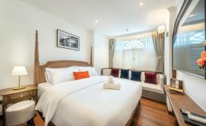 a bedroom with a large white bed and a window at Cherie Bangkok Boutique Hotel in Bangkok