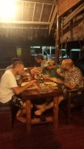 un gruppo di persone seduti intorno a un tavolo di legno di Mentawai Ebay Playground Surfcamp a Masokut