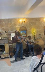 a group of people playing guitars in a room at Costas Inn in Spílion
