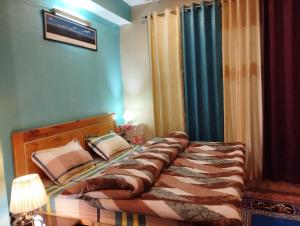 a bedroom with a large bed with at Himalayan Heights Bara Devi in Nainital