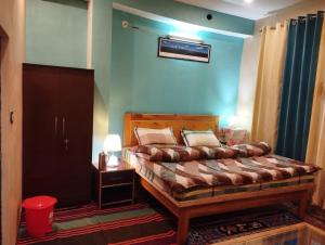 a bedroom with a bed and a blue wall at Himalayan Heights Bara Devi in Nainital