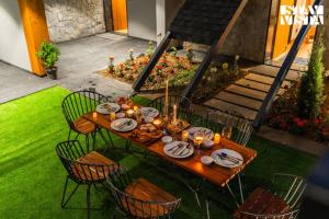 a wooden table with plates of food on it at StayVista at Shai Sher Estate with Bonfire, BBQ and Lawn in Shimla