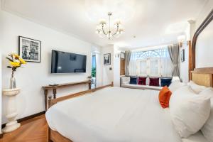 um quarto com uma grande cama branca e uma televisão em Cherie Bangkok Boutique Hotel em Bangkok