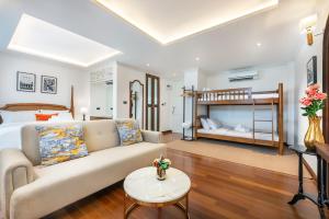 a living room with a couch and a bed at Cherie Bangkok Boutique Hotel in Bangkok