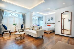 a bedroom with a bed and a couch and a mirror at Cherie Bangkok Boutique Hotel in Bangkok