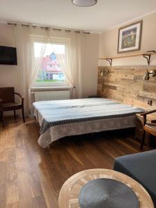 a bedroom with a large bed and a window at Dom Wczasowy Dorja in Jastarnia