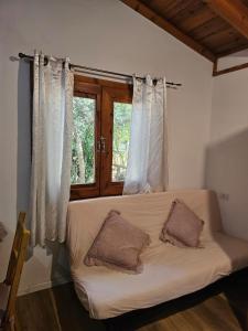 a white couch in a room with a window at Zimmer In The Garden in Karmiel