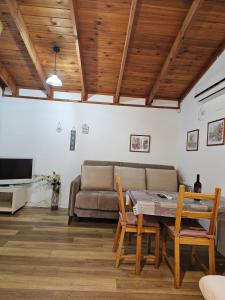 a living room with a couch and a table and chairs at Zimmer In The Garden in Karmiel