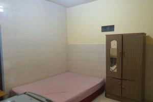Kleines Zimmer mit einem Bett und einem Schrank in der Unterkunft OYO 93895 Koh Wat Homestay Syariah in Plosobegem