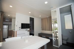 a kitchen with a white table in a room at SUNNY Mobile Homes Bijela Uvala in Poreč