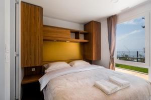 a bedroom with a large bed with two towels on it at SUNNY Mobile Homes Bijela Uvala in Poreč