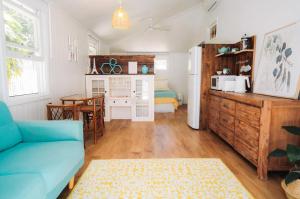 Lavender Lane Country Cottages في Kenilworth: غرفة معيشة مع أريكة زرقاء ومطبخ