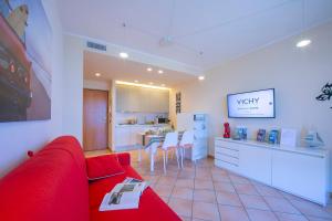 un soggiorno con divano rosso e una cucina di Appartamento Vista Lago - Happy Rentals a Desenzano del Garda