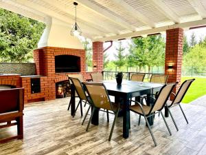a patio with a table and chairs and a fireplace at Almahaus in Avrig