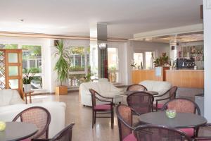 a living room with tables and white furniture and windows at Hotel La Torretta Bramante in Rimini