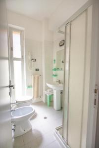 a white bathroom with a toilet and a sink at Hotel La Torretta Bramante in Rimini