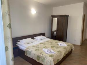 1 dormitorio con 1 cama con toallas en The Stream Resort, en Pamporovo