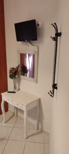 a white table with a mirror and a tv on a wall at Katerina Irida in Mérikhas
