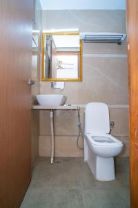La salle de bains est pourvue d'un lavabo, de toilettes et d'un miroir. dans l'établissement Aster Studio Sec-39 Gurgaon I Fully furnished 2BHK, à Gurgaon