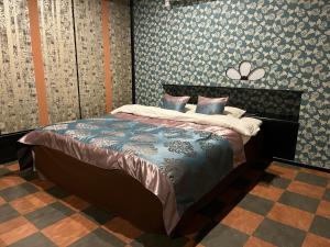 a bedroom with a bed in a room with wallpaper at HOTELウォーターゲート蟹江（カップル専用） in Kanie