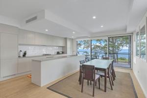 a kitchen with a table and chairs in a room at The Beach Apartment in Huskisson