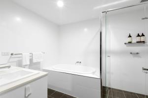 a white bathroom with a sink and a shower at The Beach Apartment in Huskisson +10 photos