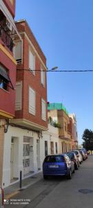 a blue car parked on a street next to buildings at TU CASA en Benetússer , VALENCIA in Benetúser