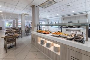 a buffet line with plates of food in a restaurant at O7 Aloe Corralejo in Corralejo