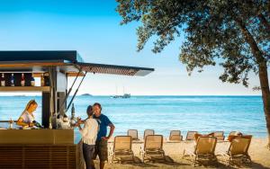 Ein Mann und eine Frau stehen an einer Bar am Strand in der Unterkunft Maistra Camping Amarin Pitches in Rovinj