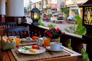 einen Tisch mit Frühstückszutaten und Getränken auf dem Balkon in der Unterkunft Pakse hotel & Restaurant in Pakse