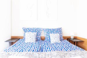 un letto con lenzuola e cuscini blu e bianchi di Pokoje Gościnne Raf-Tur - Sala Zabaw, Grill - Idealny dla rodzin z dziećmi a Ostrowo Altre 62 foto