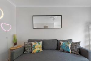 un sofá gris con almohadas en la sala de estar en Old Street Apartments By Morethanstays en Londres