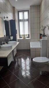 ein Badezimmer mit zwei Waschbecken, einem WC und einer Badewanne in der Unterkunft An der Neiße in Görlitz