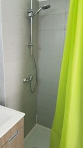 łazienka z prysznicem z zieloną zasłoną prysznicową w obiekcie Balaia Gardens, jardins da Balaia w Albufeirze